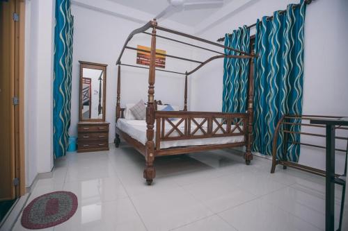 a bedroom with a canopy bed and a mirror at Panda House in Galle