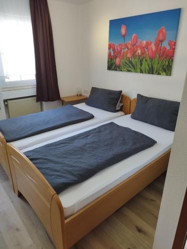 two beds in a room with red tulips at Pension Chapeau-Claque in Cochem