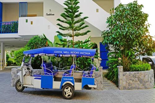 a golf cart parked in front of a building at Costa Village Jacuzzi Bangsaray in Bang Sare