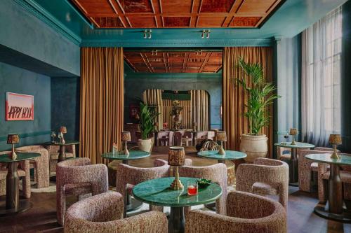 a restaurant with tables and chairs in a room at Ember Locke Kensington in London