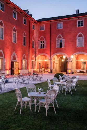 a group of tables and chairs in front of a building at Castello di Morozzo Guest House in Morozzo