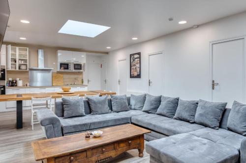 a living room with a couch and a table at Loft pour 14 personnes in Saint-Étienne-du-Rouvray