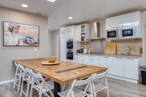 a kitchen with a wooden table and white cabinets at Loft pour 14 personnes in Saint-Étienne-du-Rouvray