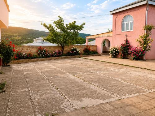 a pink building with flowers in front of it at Qecresh Garden House in Qǝçrǝş