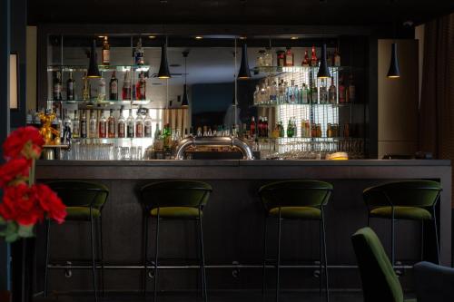 a bar with green bar stools in a room at Best Western Hotel le Galice Aix-en-Provence in Aix-en-Provence