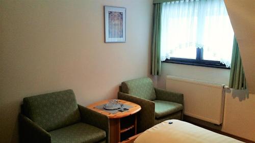 a room with two chairs and a table and a window at Waldhotel Zöbischhaus in Bad Reiboldsgrün