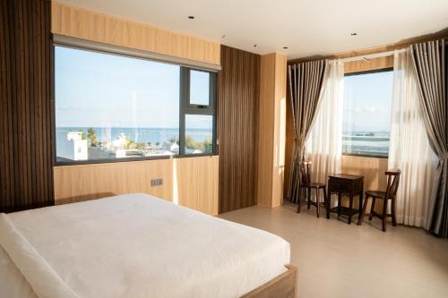 a bedroom with a bed and a table and chairs at Alphan Hotel in Vạn Ninh