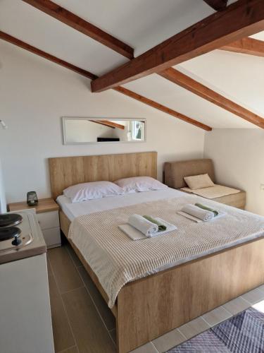 a bedroom with a bed with two towels on it at Apartmani Mandić in Neum