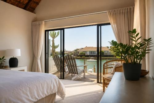 a bedroom with a bed and a view of a patio at CANAL GUEST HOUSE - Waterfront Boutique B&B in St Francis Bay