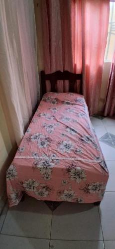 a bed with a pink comforter on it in a bedroom at CasaLima in Bragança