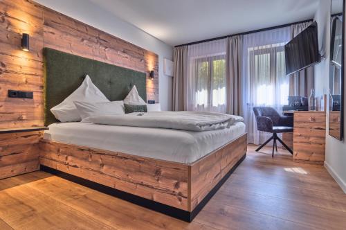 a bedroom with a large bed with a wooden wall at Annies Bergwelt Haus Waldliebe in Bodenmais