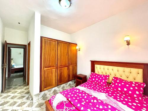 a bedroom with a bed with pink polka dot sheets at Résidence T&M ODZA Yaoundé Cameroun in Méhandan
