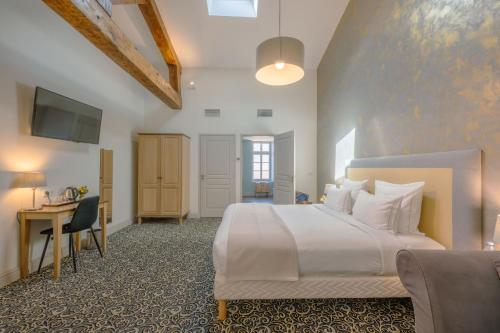 ein Schlafzimmer mit einem großen weißen Bett und einem Schreibtisch in der Unterkunft Hotel Heritage in Cognac