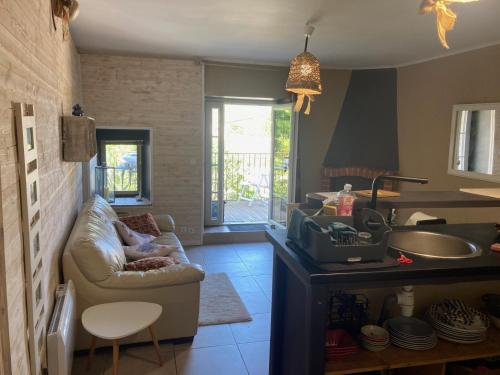 a living room with a couch and a kitchen at La petite maison in Lagorce