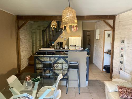 a kitchen with a counter and a table and chairs at La petite maison in Lagorce