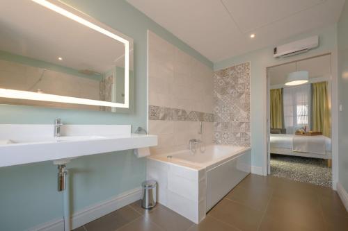 ein Badezimmer mit zwei Waschbecken und einem Spiegel in der Unterkunft Hotel Heritage in Cognac