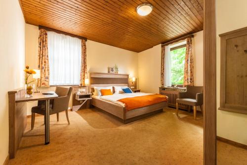 a bedroom with a bed and a desk and a window at Löwen Hotel & Restaurant in Marktbreit