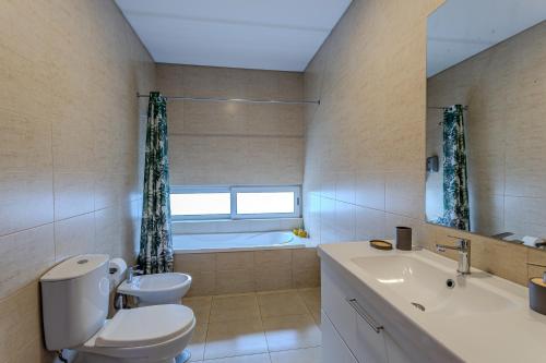 a bathroom with a toilet and a sink and a tub at Quinta De Santana in Rabo de Peixe