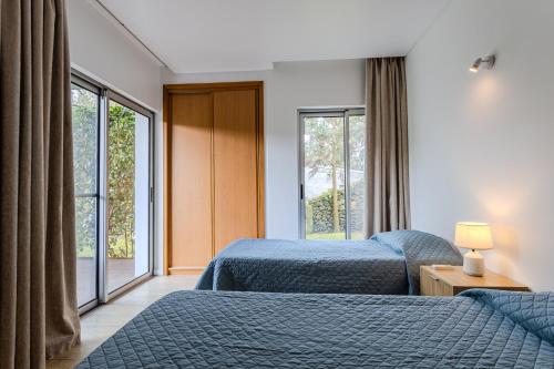 a hotel room with two beds and a window at Quinta De Santana in Rabo de Peixe