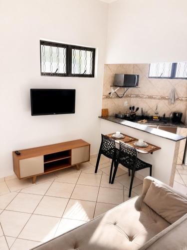 a living room with a couch and a table at Studio aconchegante com ar-condicionado e Smart TV in Bauru