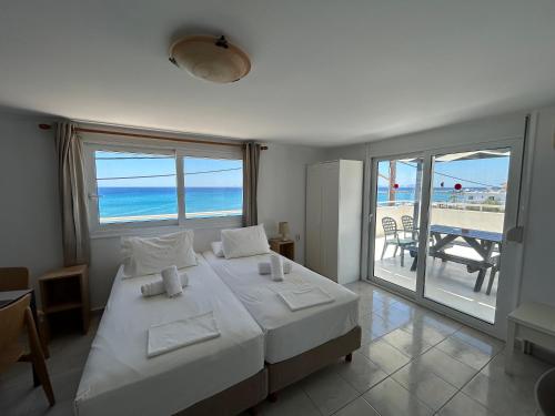 a bedroom with a bed and a view of the beach at Annoula Studios and Apartments in Kardamaina