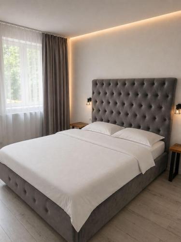 a bedroom with a large bed with a large white bedspread at Terasa Baniei in Bucovăţ