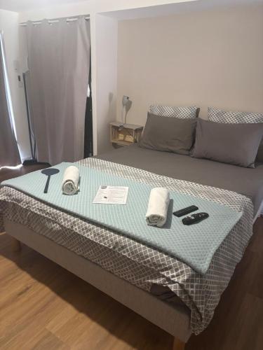 a bed in a room with towels on it at Studio piscine in Puy-Guillaume