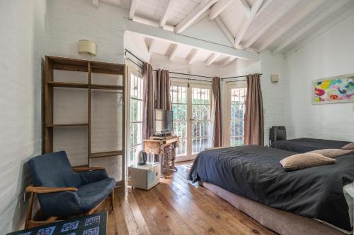 a bedroom with a bed and a chair and a window at Casa Campo Hotel Boutique - San Pedro in San Pedro
