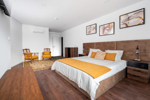 a bedroom with a large bed and a table and chairs at AL Hirondelle in Sernancelhe