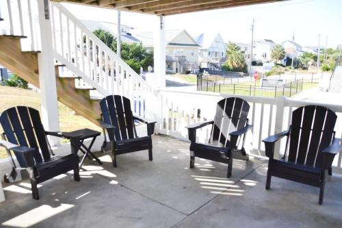 three chairs sitting on a porch with a staircase at Steps to Beach 2BR 2BA duplex in Atlantic Beach