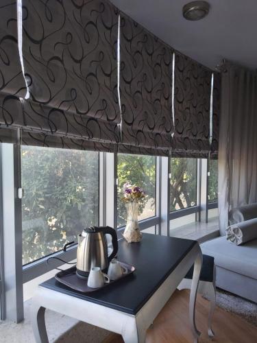 a tea kettle on a table in front of a window at Hotel Kocibelli POOL & SPA in Korçë