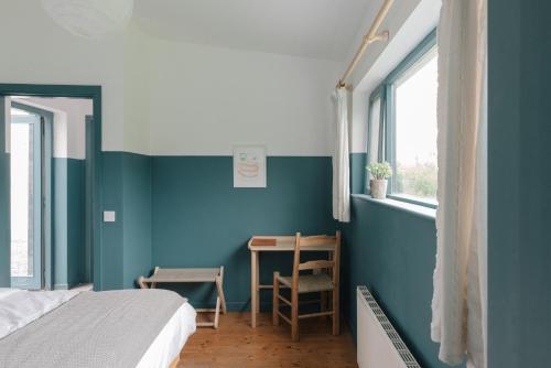 a bedroom with blue walls and a desk and a bed at The Common Knowledge Centre in Kilfenora