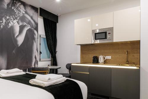 a room with a kitchen with a bed and a sink at Maison Astéria in Nice