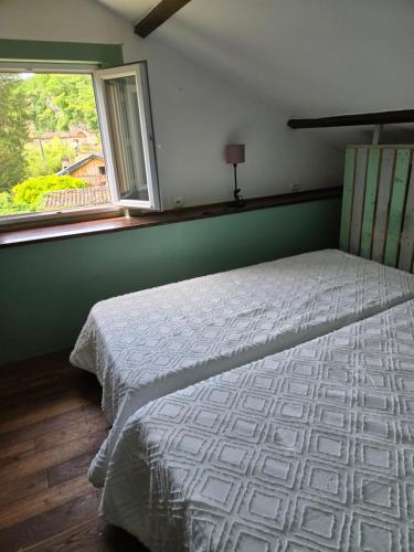 a bedroom with a bed and a window at Les Rochers de Bayac in Bayac