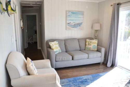 a living room with a couch and a chair at Oceanfront Townhouse steps to the Beach in Atlantic Beach