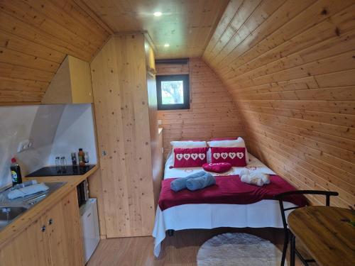 a small room with a bed in a wooden cabin at As casinhas do Moinho in Valença