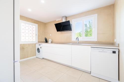 a kitchen with a sink and a dishwasher at Villas2meet La Siesta in Cala Romàntica