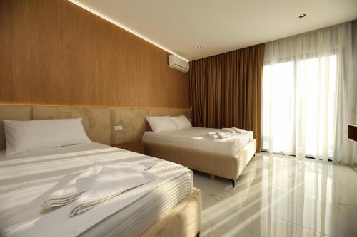 a hotel room with two beds and a window at LiEl Holiday in Vlorë