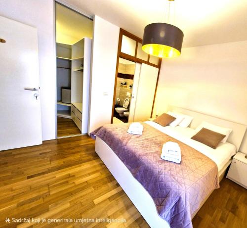 a bedroom with a large bed with a purple blanket at Rooms Hana Rovinj in Rovinj