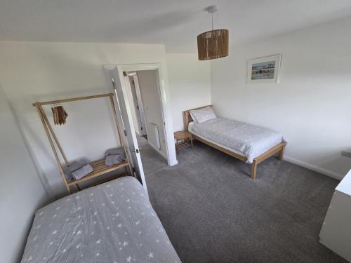 a room with two beds and a mirror in it at Lower Townhouse, Exeter in Alphington
