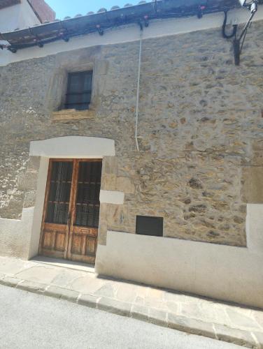 a stone building with a door and a window at Els Sifons in Castelltersol