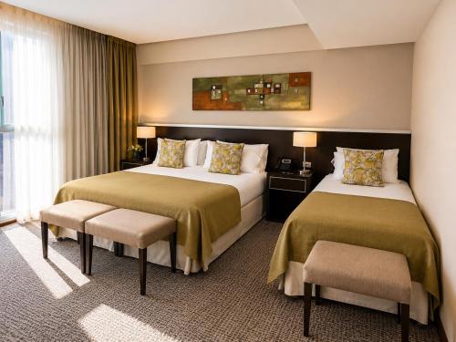 a hotel room with two beds and a window at Konke Buenos Aires Hotel in Buenos Aires