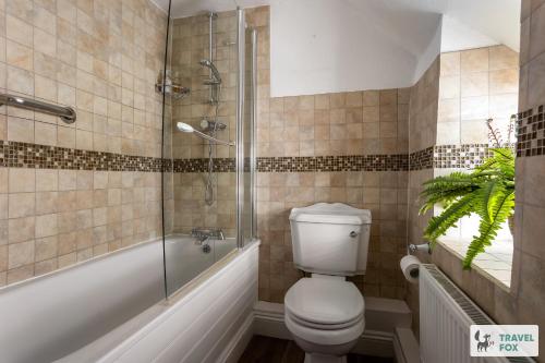 a bathroom with a toilet and a glass shower at Charlotte's Cottage, a Charming Cotswolds Getaway in Adlestrop