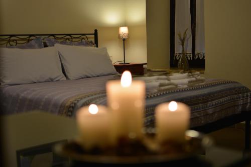 a room with a bed with candles on a table at Gartagani Guest House in Stemnitsa