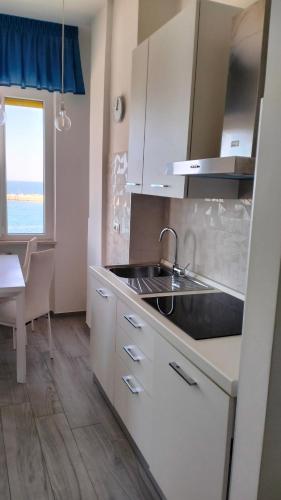a kitchen with a sink and a table and a window at IL CIELO SUL MARE in Bisceglie