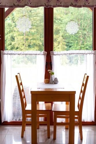 a dining room table and chairs in front of a window at Cudne Manowce in Wisła