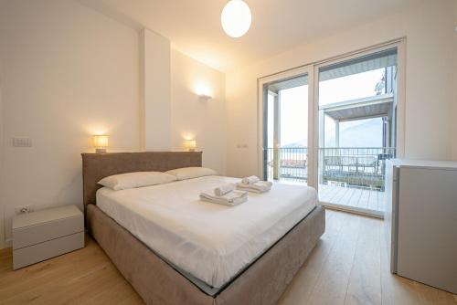 ein Schlafzimmer mit einem großen Bett und einem großen Fenster in der Unterkunft Appartamento Due Stelle Musso in Musso
