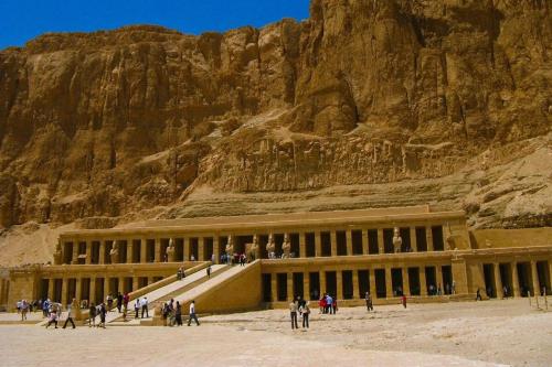 a group of people standing outside a building in front of a mountain at Vipxplor Travel in Luxor