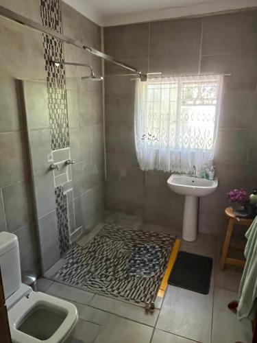 ein Badezimmer mit Dusche und Waschbecken in der Unterkunft DKC Accommodation in Sutherland