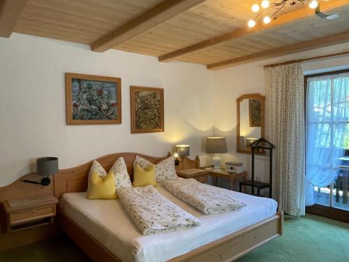a bedroom with a bed with yellow pillows at Haus Lukaswinkl in Schönau am Königssee